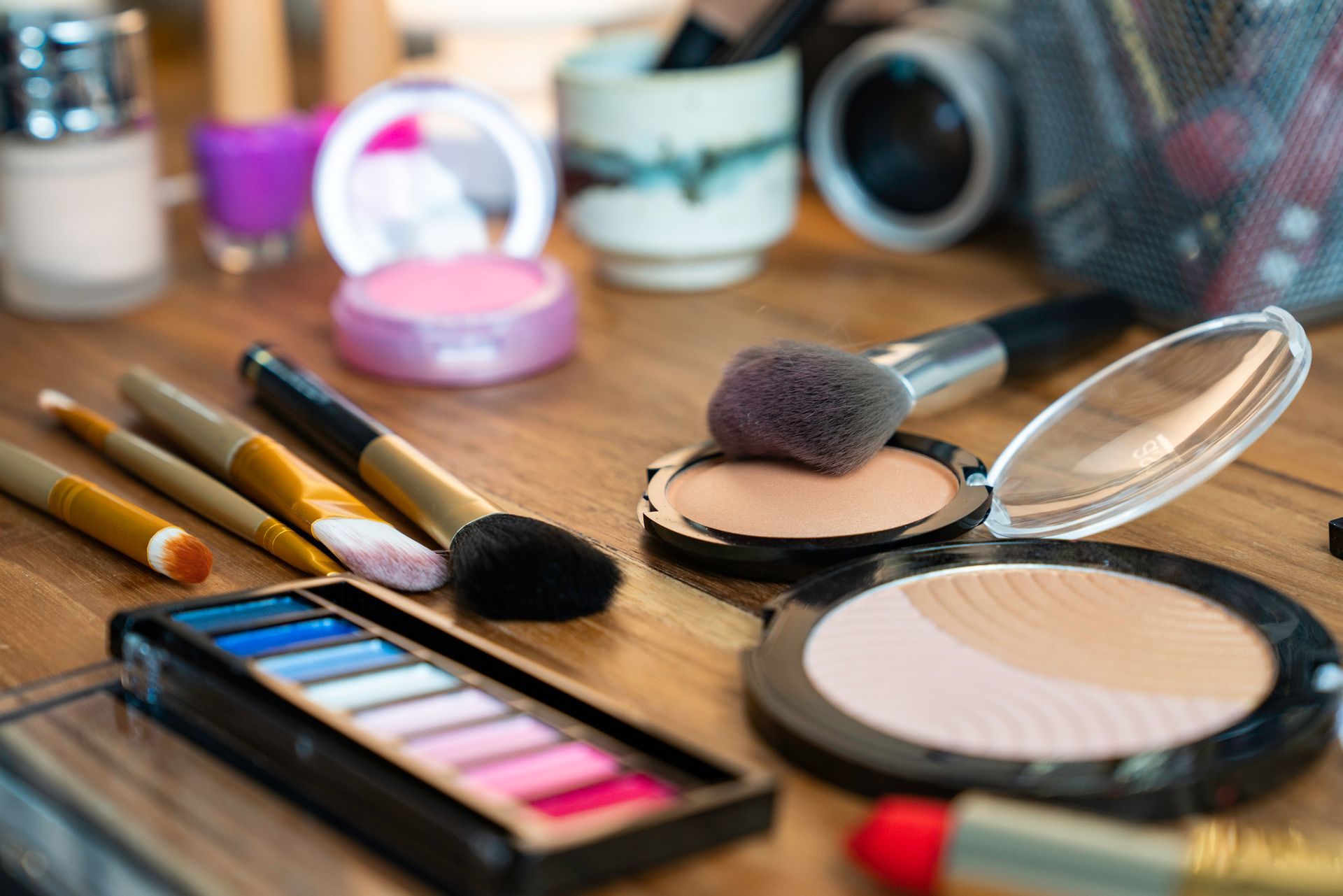 A table topped with a variety of makeup products and brushes.