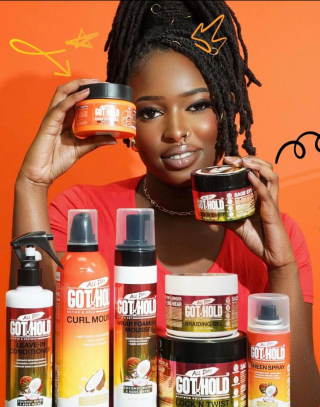 A woman is brushing a wig with a brush.