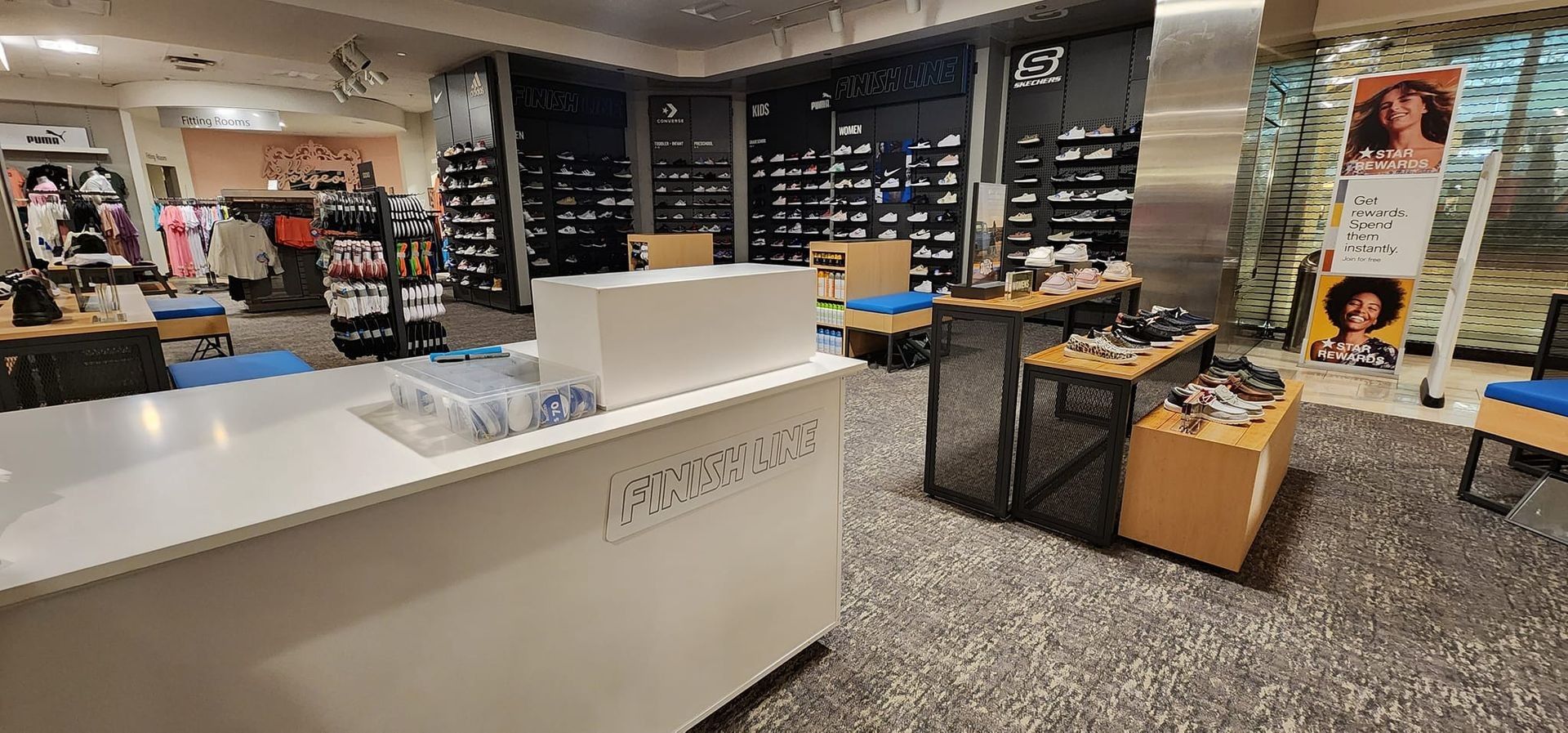 The inside of a shoe store with a counter and tables.