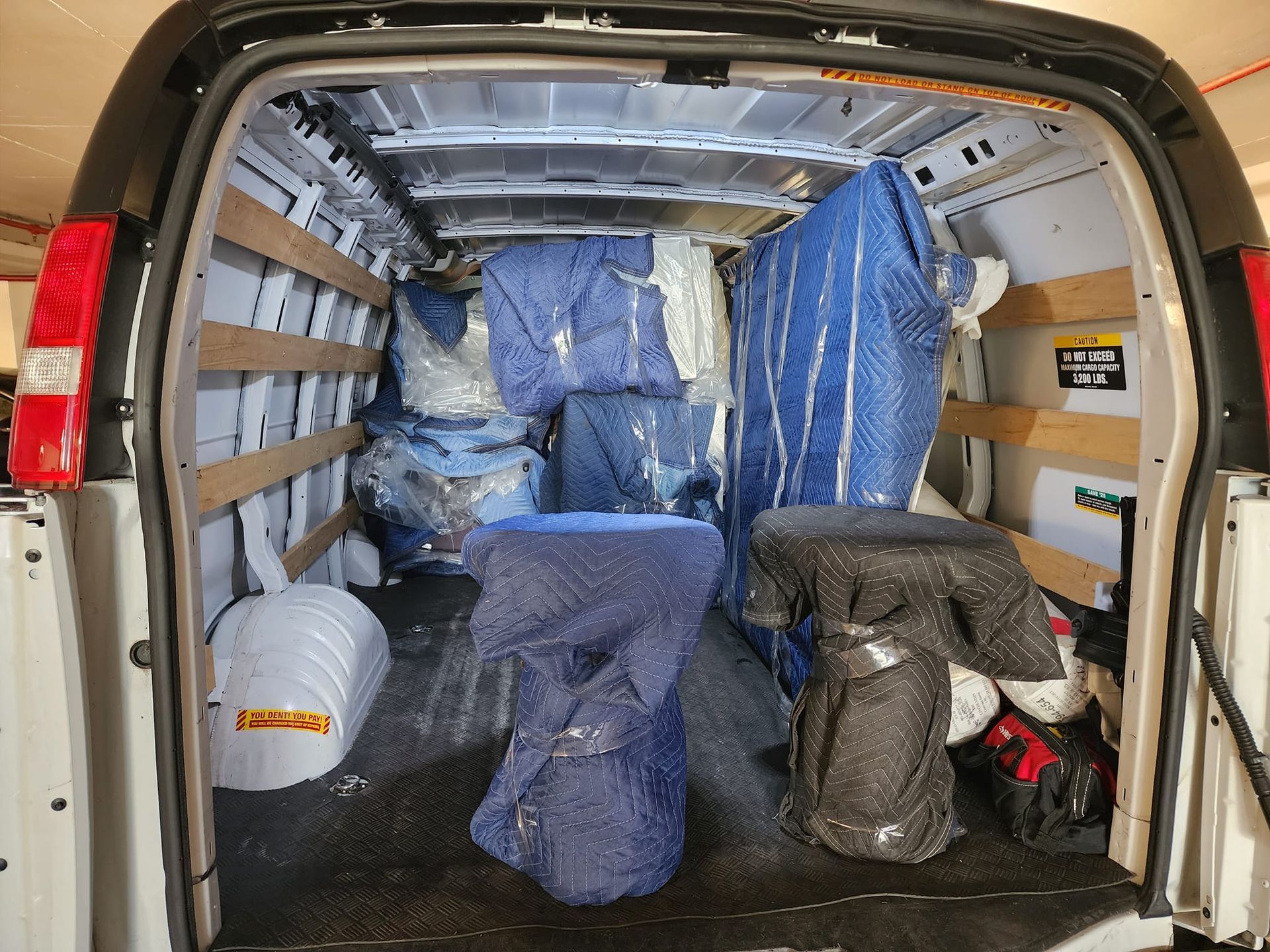 The back of a van is filled with lots of moving supplies