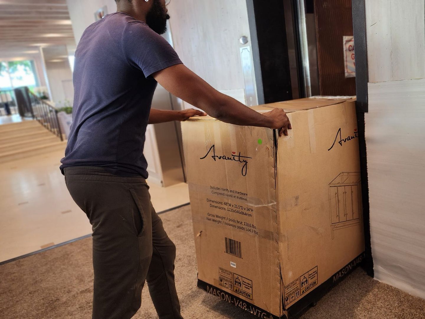 A man is pushing a cardboard box