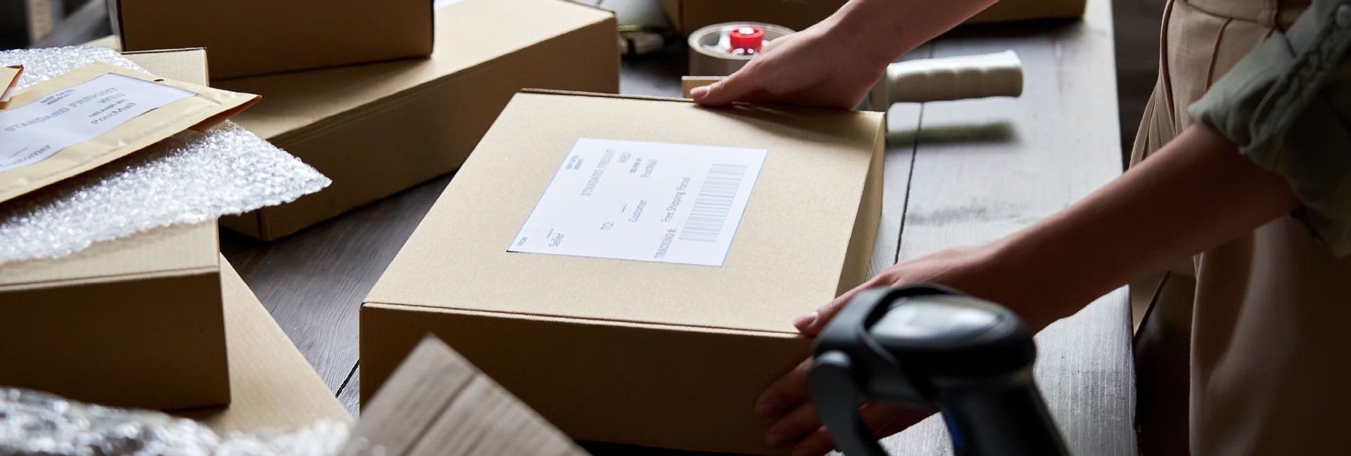 A person is scanning a box with a barcode scanner.