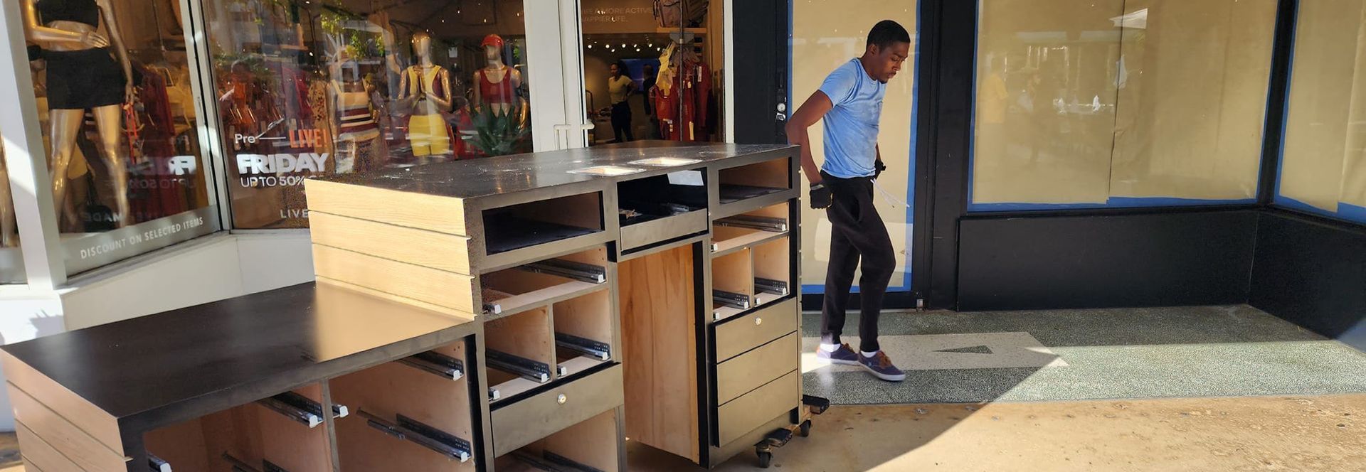 A man is standing in front of a counter in a store.