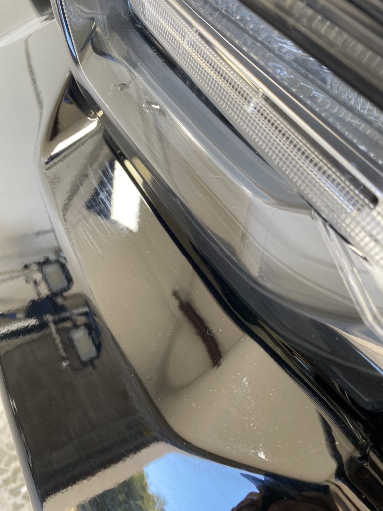 A close up of a car 's bumper and headlight.