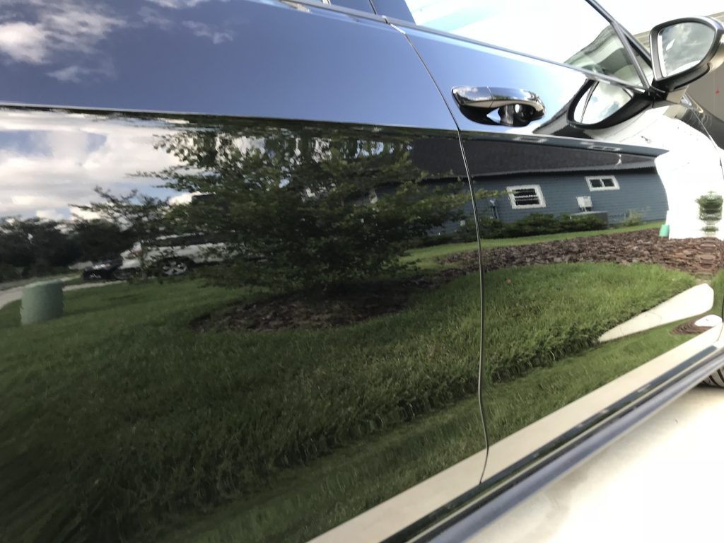 A black car is parked in front of a house