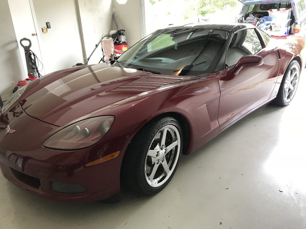 A red sports car is parked in a garage.