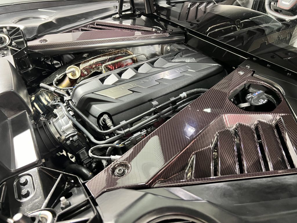 A close up of the engine of a car with the hood open.