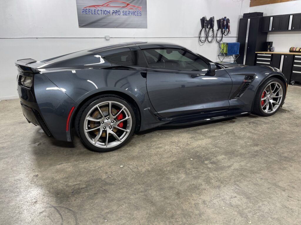 A gray corvette zr1 is parked in a garage.