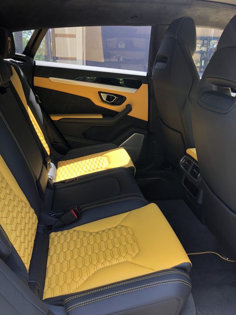 The back seat of a car with yellow and black seats