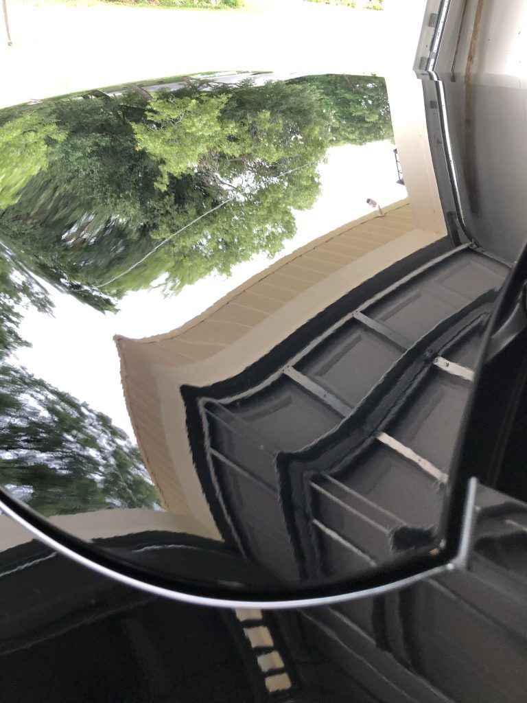 A close up of a reflection of a car in a mirror.