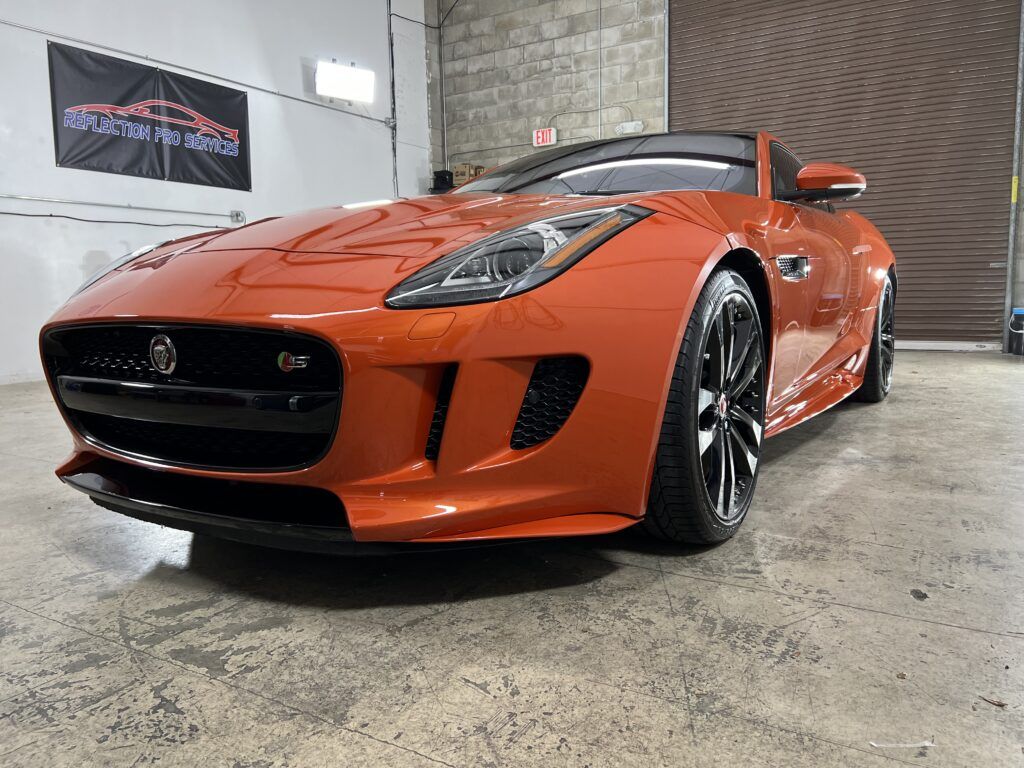 A red sports car is parked in a garage.