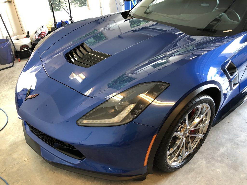 A blue sports car is parked in a garage.