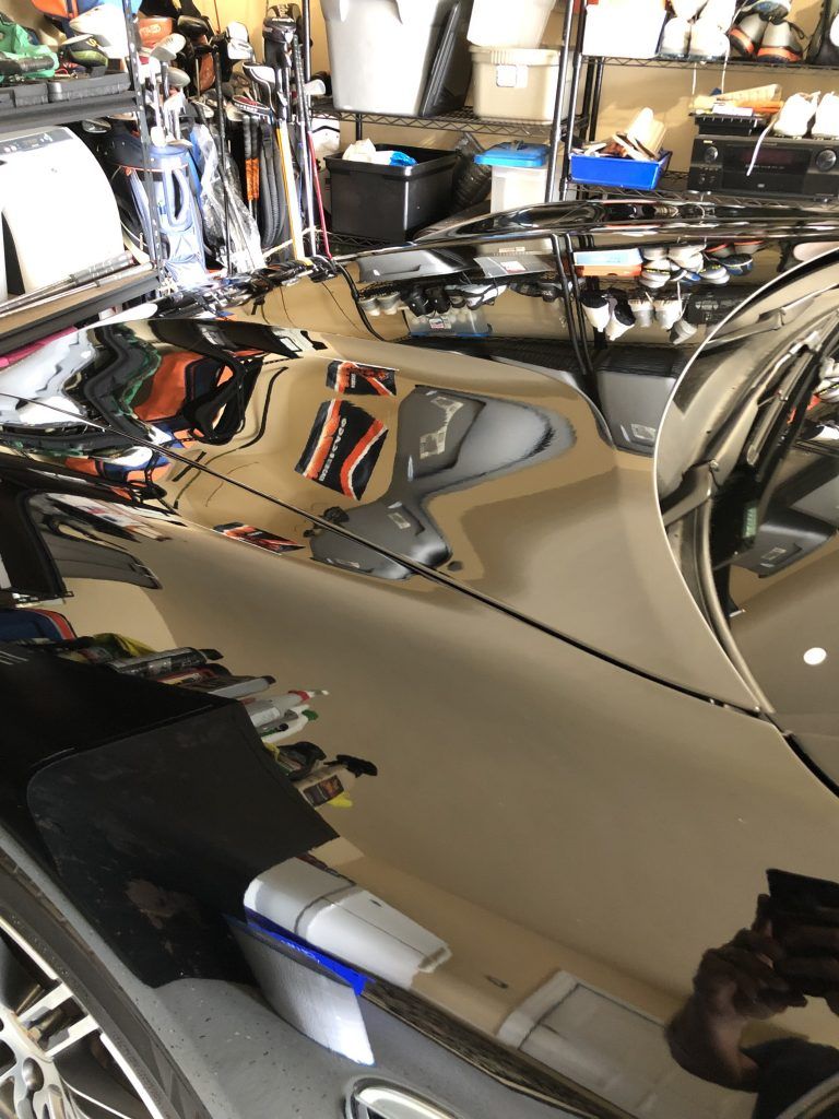 A reflection of a car in a mirror in a garage