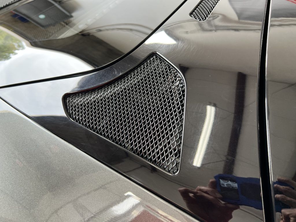 A close up of a car hood with a grille on it