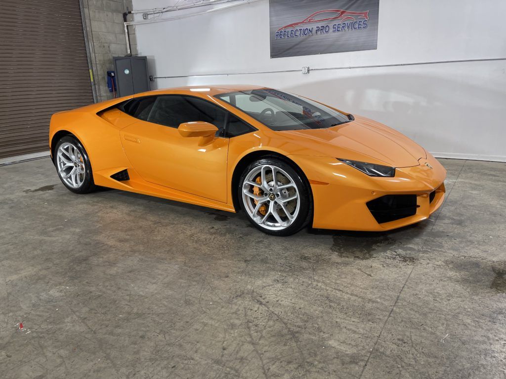 A yellow lamborghini huracan is parked in a garage.