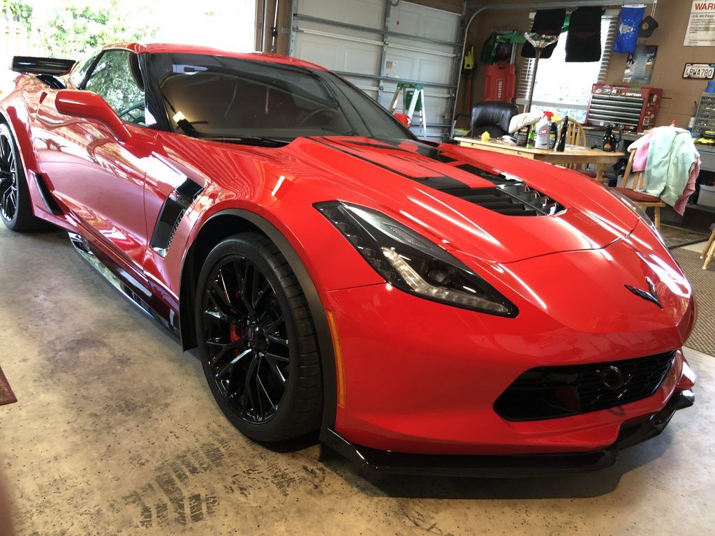 A red sports car is parked in a garage.