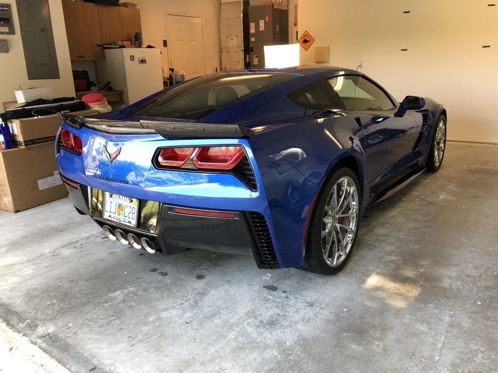 A blue sports car is parked in a garage.