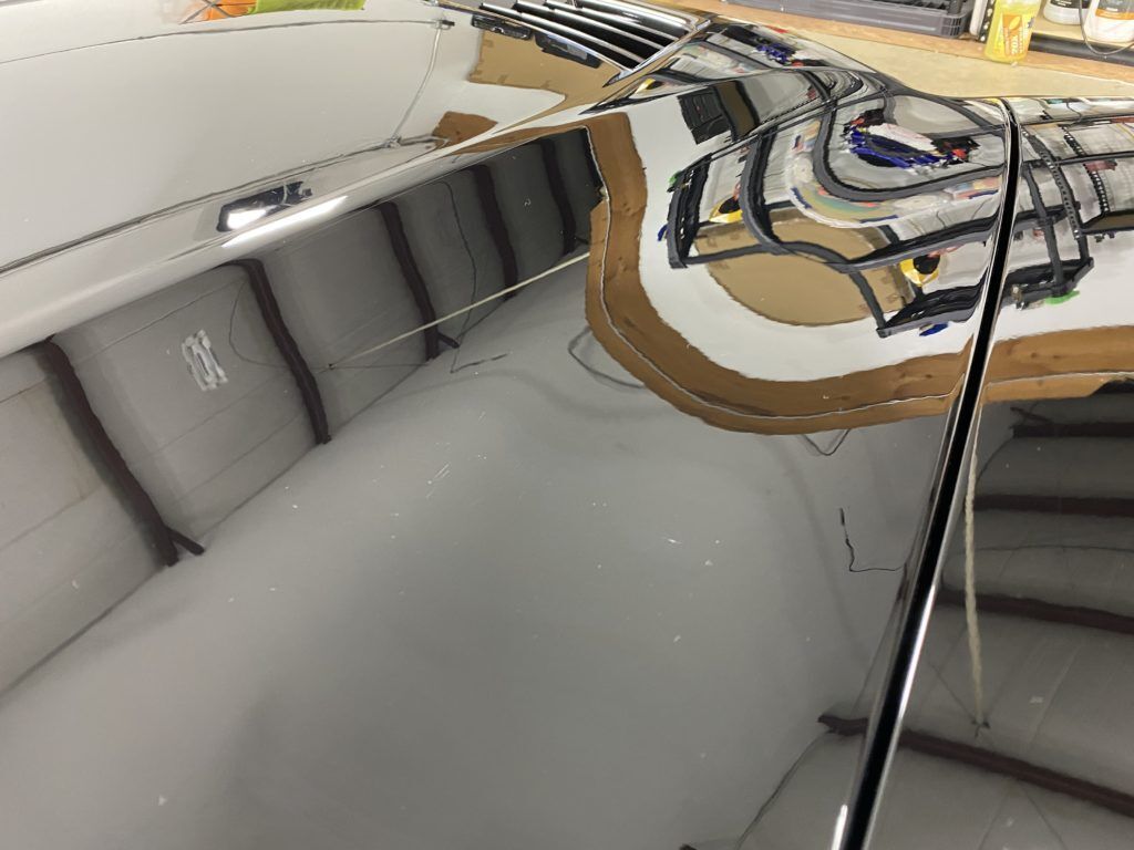 A close up of a mirror with a reflection of a boat in it.