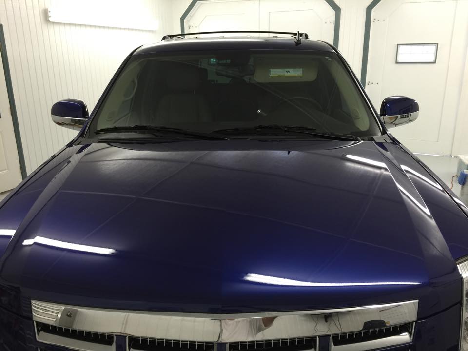 A blue ford expedition is parked in a garage