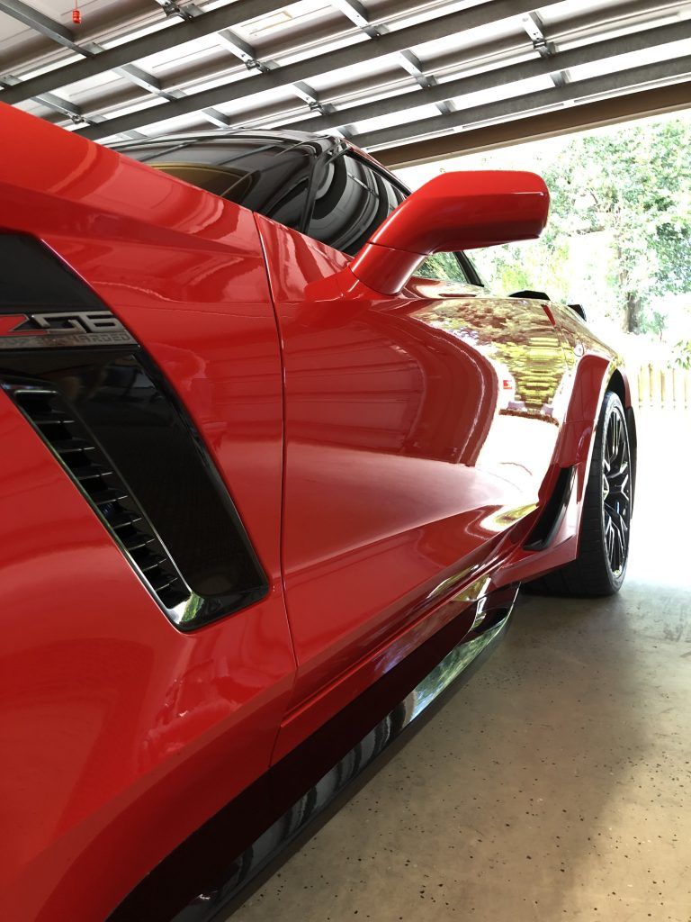 A red sports car is parked in a garage.