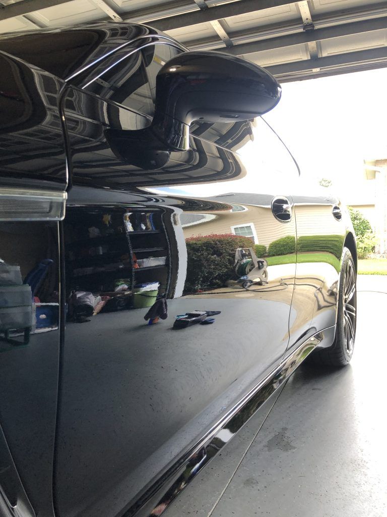 A black car is parked in a garage.