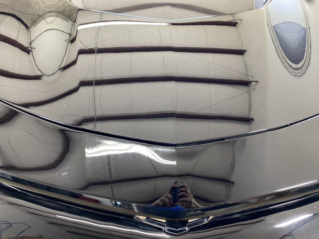 A person is taking a picture of their reflection in a mirror