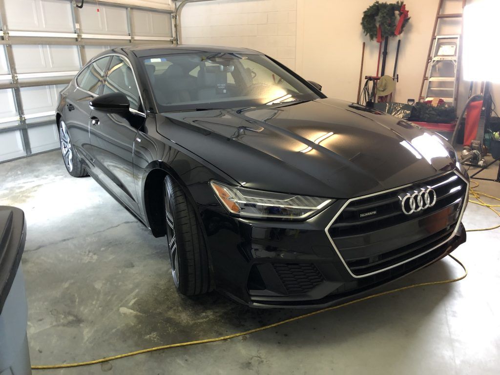 A black audi a7 is parked in a garage.