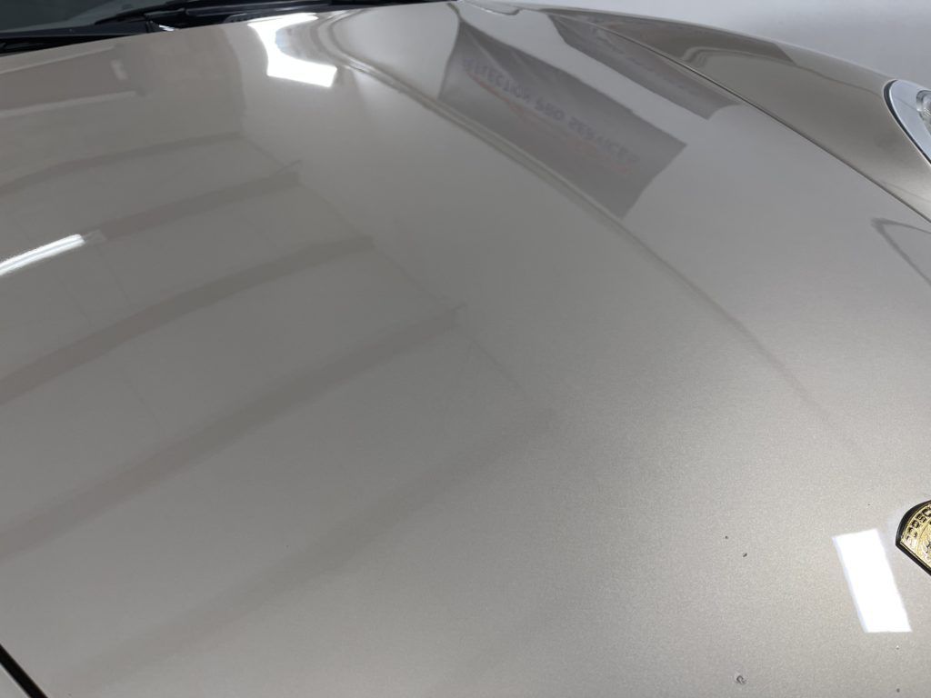 A close up of the hood of a car in a garage.