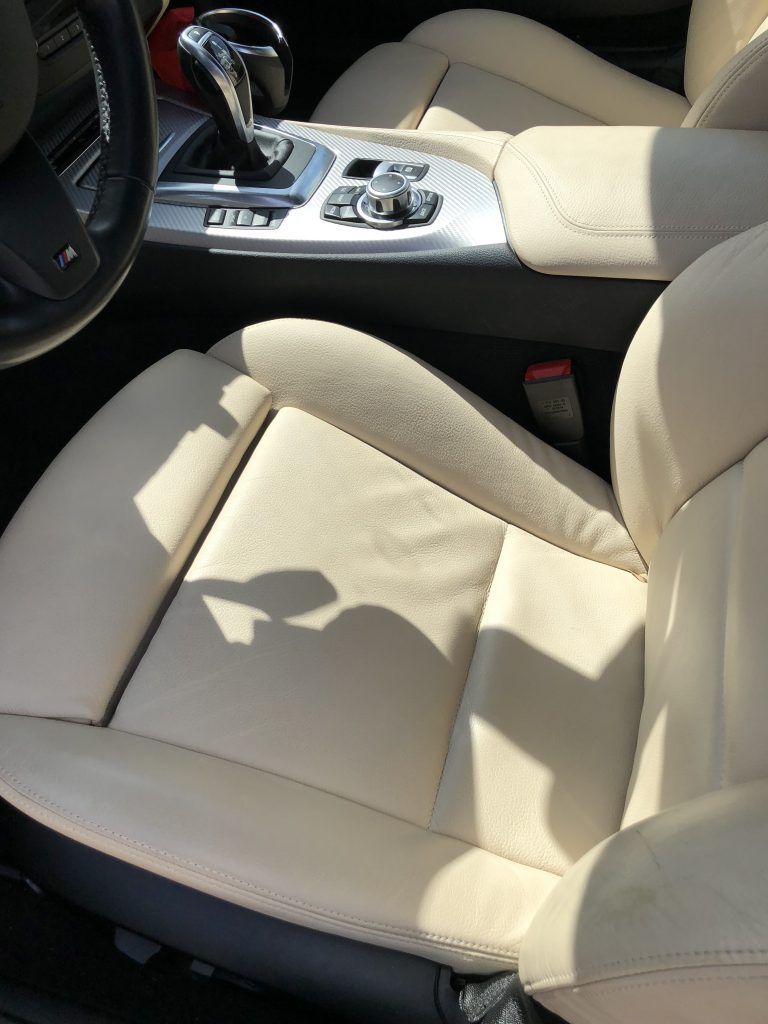 A car with white leather seats and a steering wheel