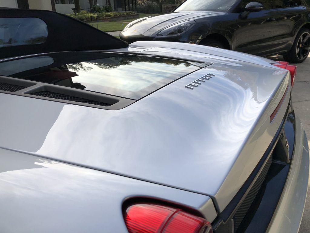 A silver car is parked next to a black car