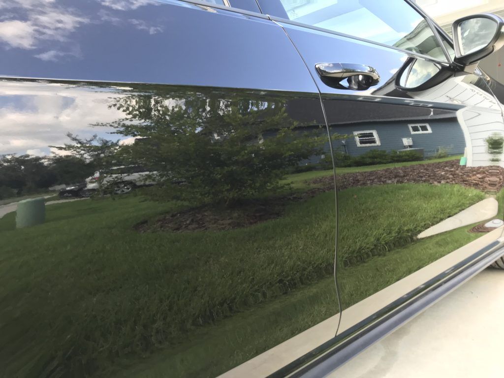 A black car is parked in front of a house