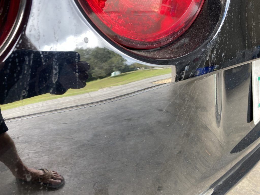 A person standing next to a car with a license plate that says florida