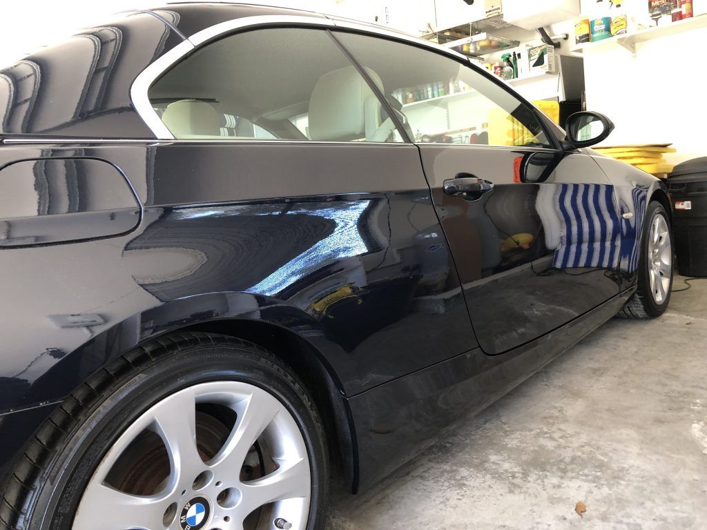 A black bmw is parked in a garage.