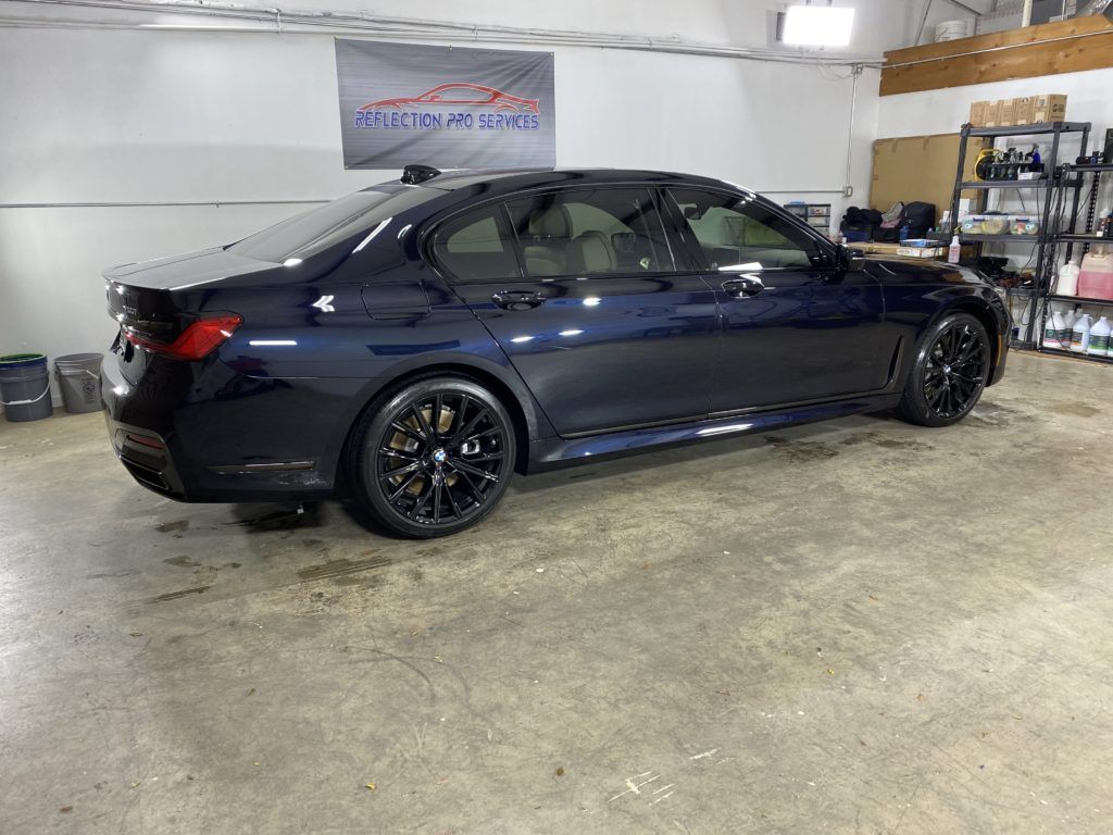 A black bmw 3 series is parked in a garage.