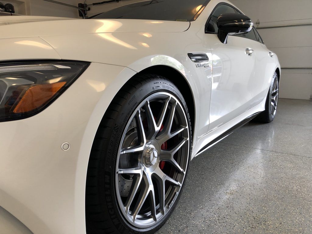 A white sports car is parked in a garage.