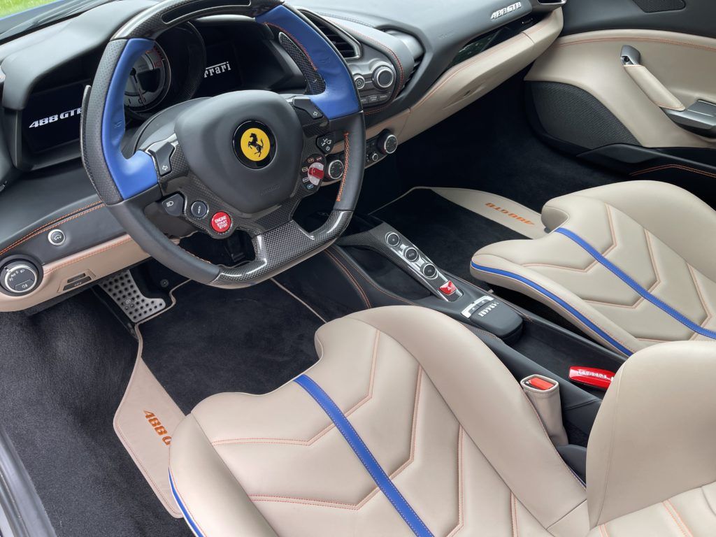 The interior of a ferrari with a steering wheel and seats