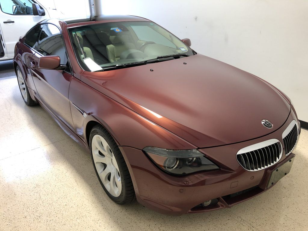 A red bmw is parked in a garage.