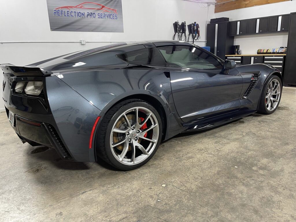 A gray corvette zr1 is parked in a garage.