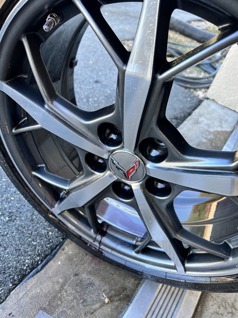 A close up of a corvette wheel on a concrete surface.