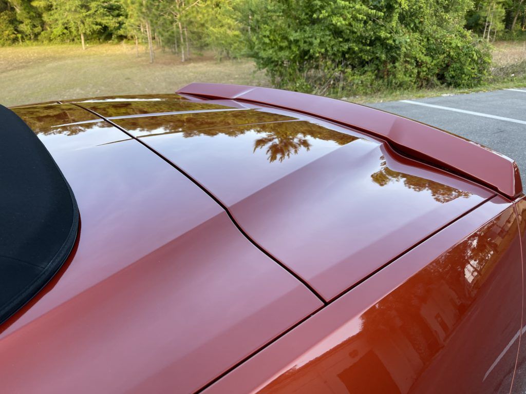 A red car is parked on the side of the road
