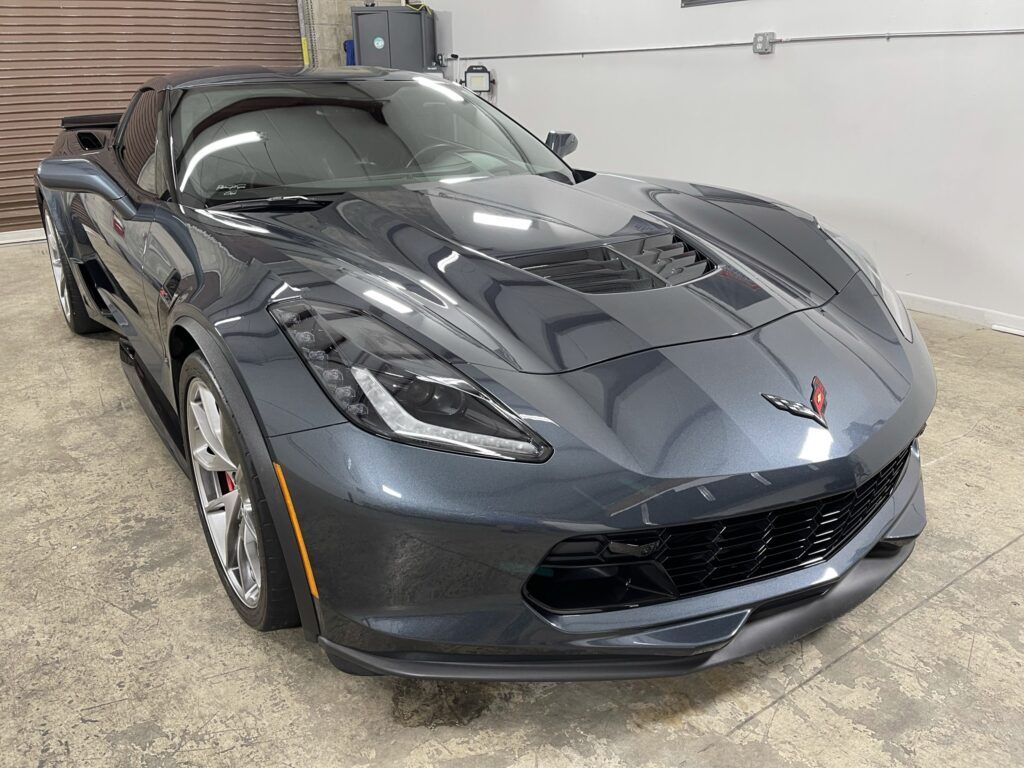 A black sports car is parked in a garage.