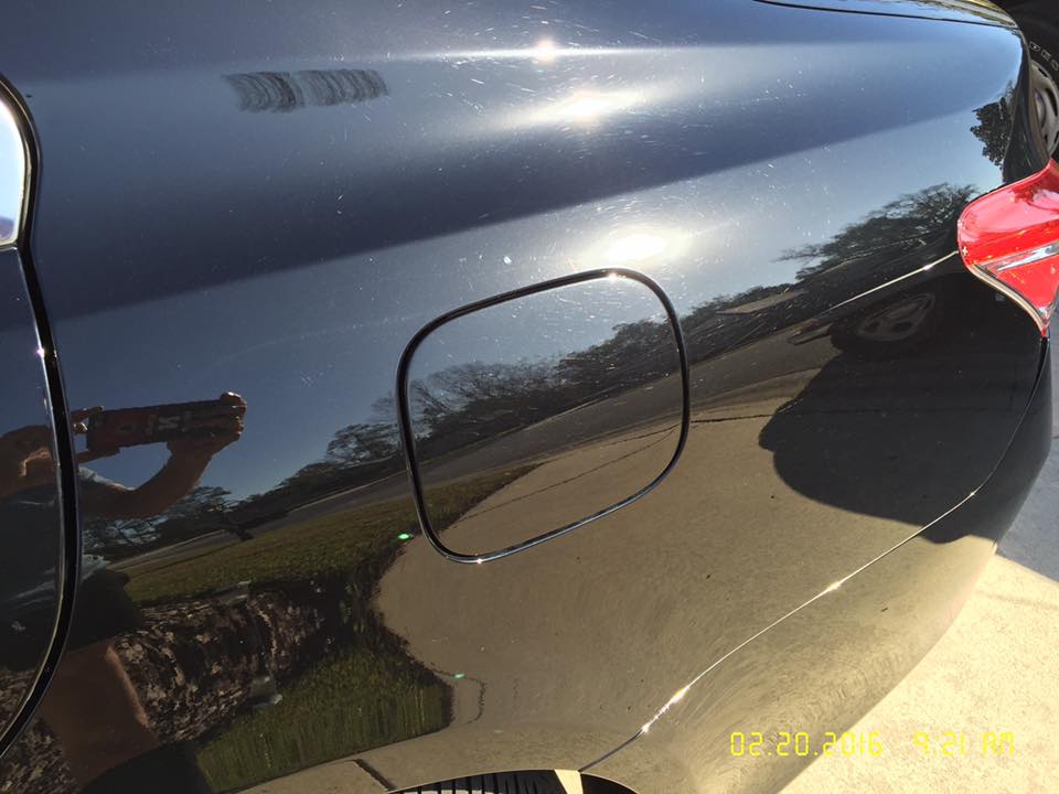 A black car is parked on the side of the road