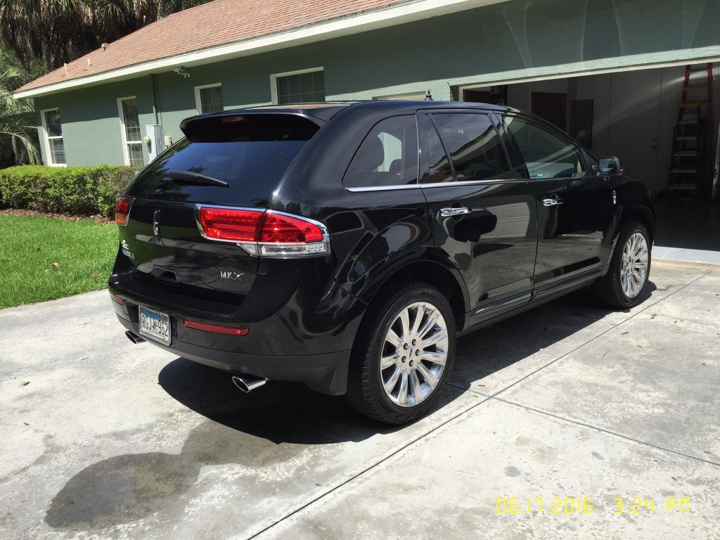 A black car is parked in front of a house