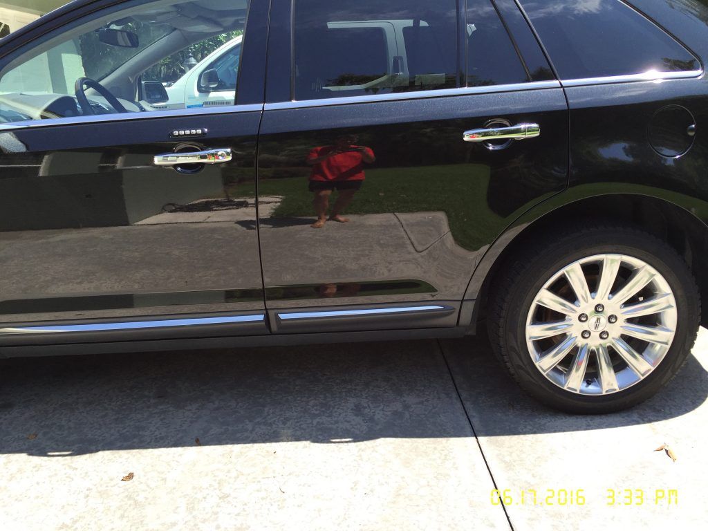 A black car is parked on the side of the road.