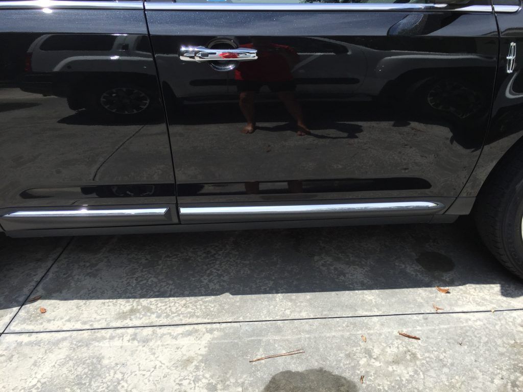 A black car is parked on the side of the road