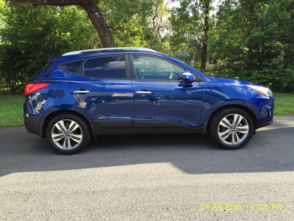A blue car is parked on the side of the road.