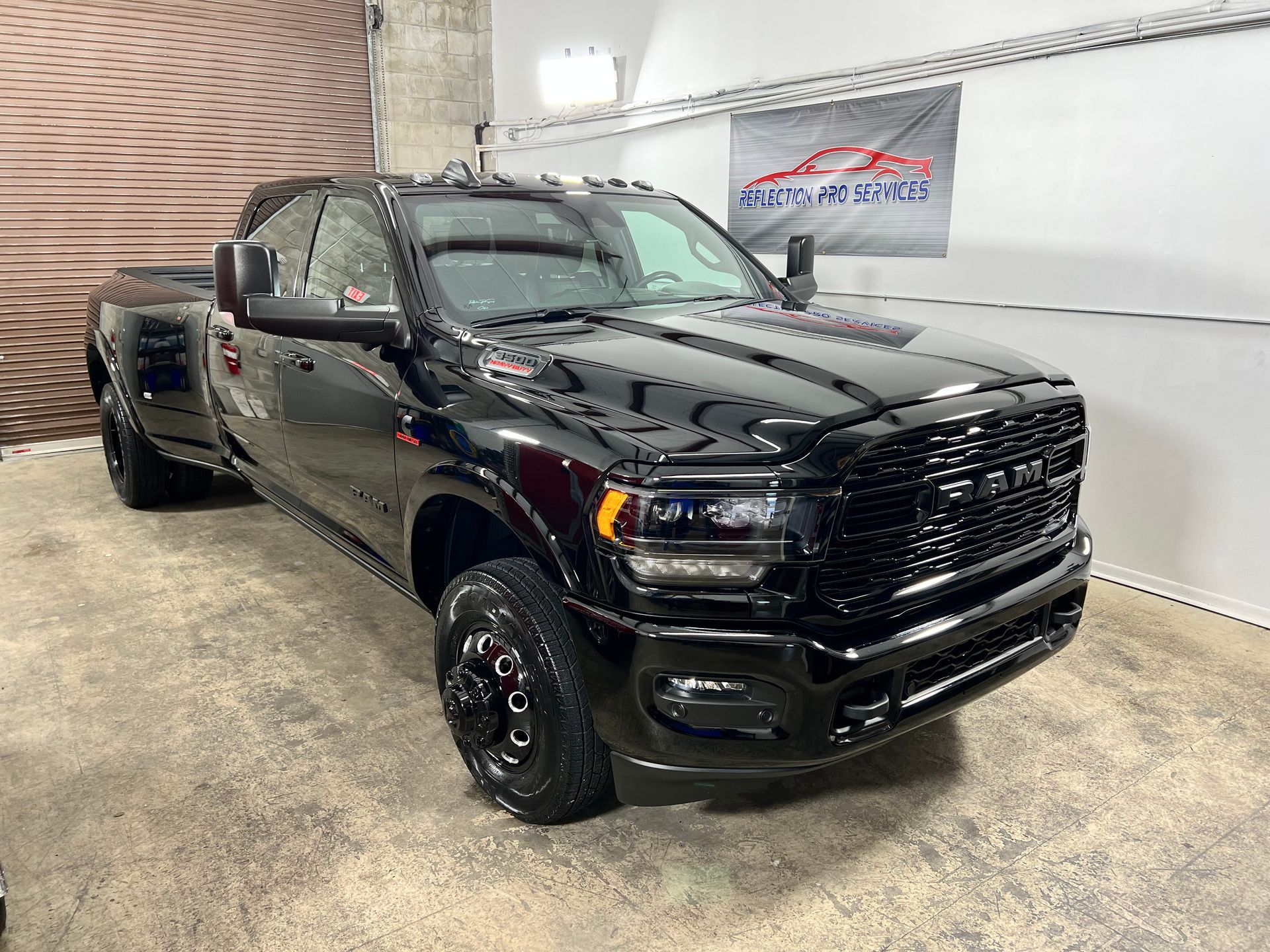 A black dodge ram truck is parked in a garage.