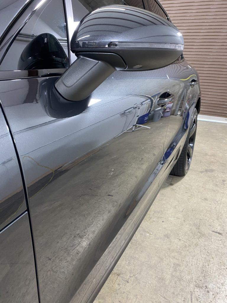 A close up of a car 's side mirror in a garage.