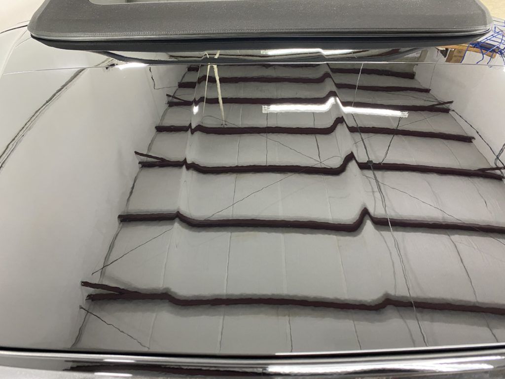 A close up of a car 's windshield with a roof rack on it.