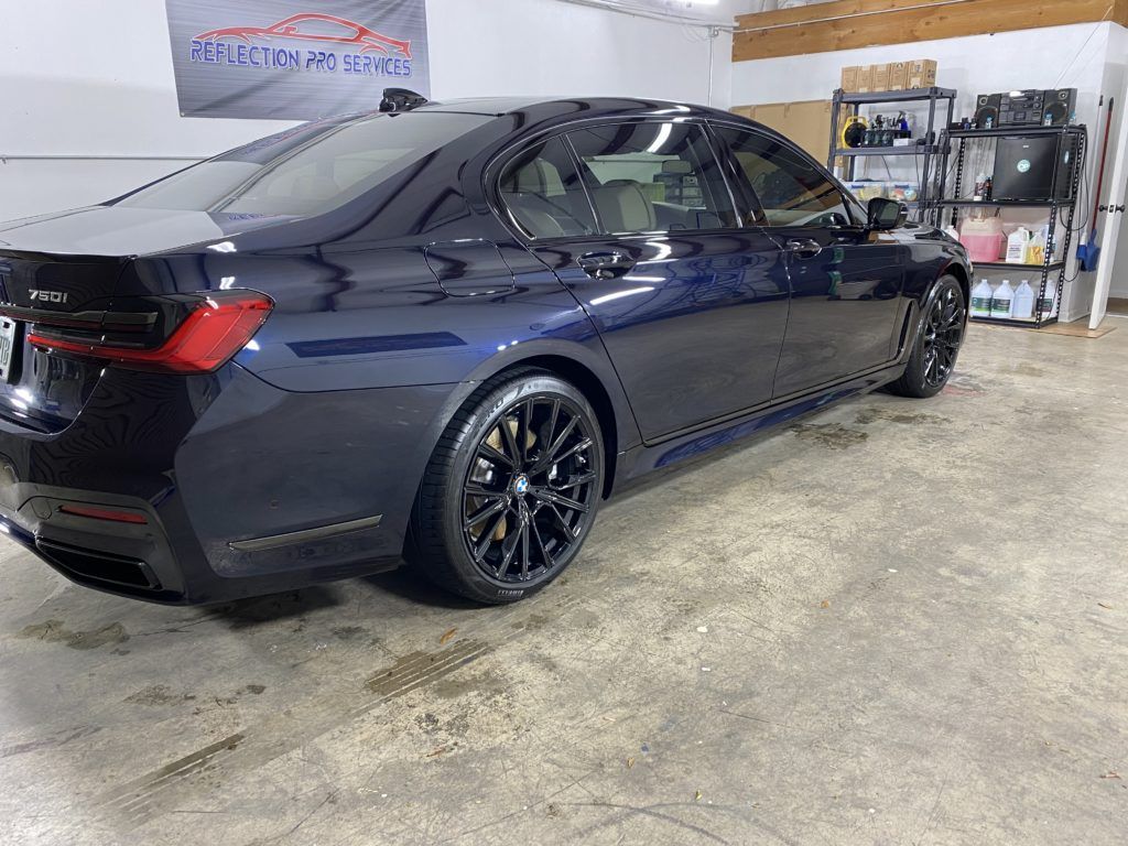 A black bmw 3 series is parked in a garage.